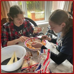 Students making wraps with host family